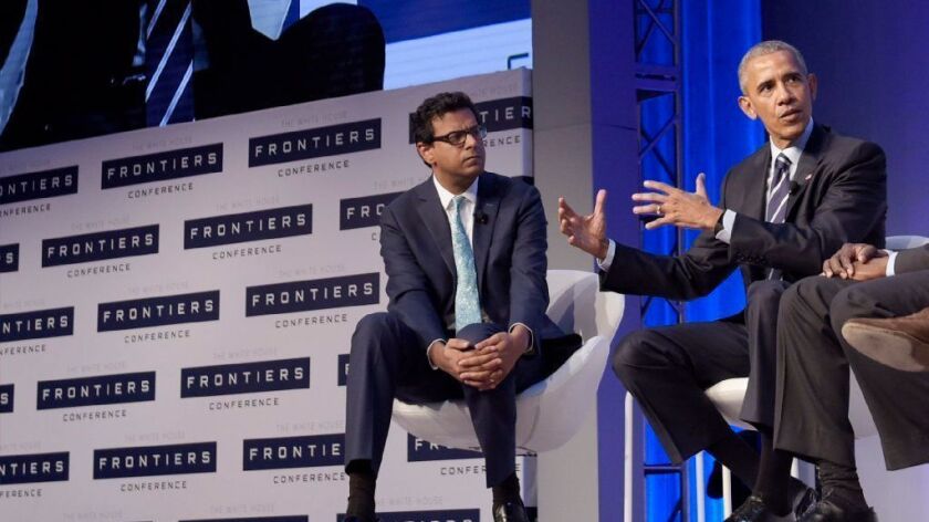 Dr. Atul Gawande, left, listens to then-President Obama speak at a 2016 conference.