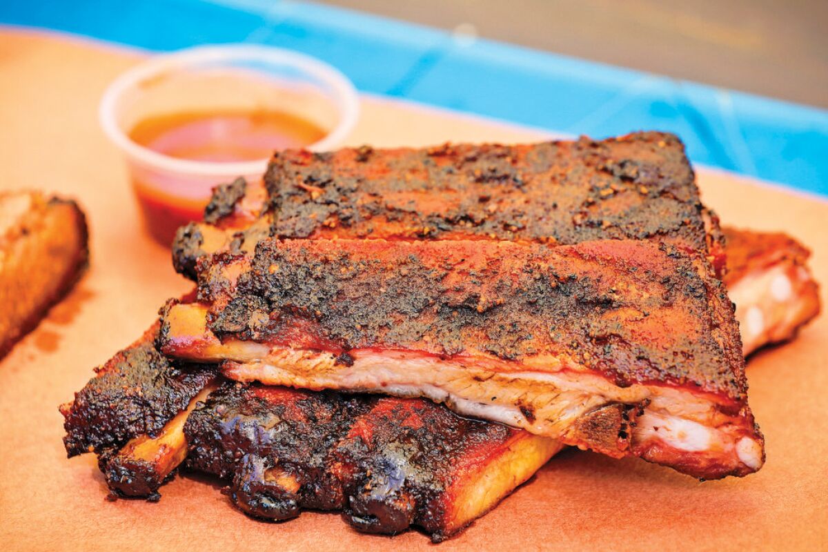 A pile of slow-cooked pork spareribs sits on butcher paper. 