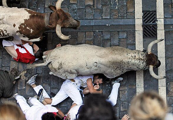 Revelers are stepped over and upon during the bull run. Officials said later there were no serious injuries. Spaniards trace the origins of the event to the 13th or 14th century.