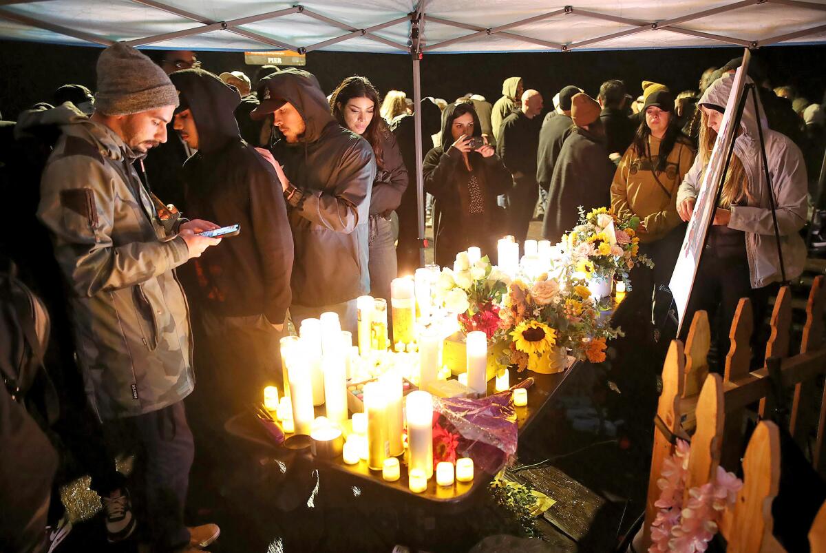 Friends gather around a shrine during a candlelight vigil in honor of Tatum Goodwin.