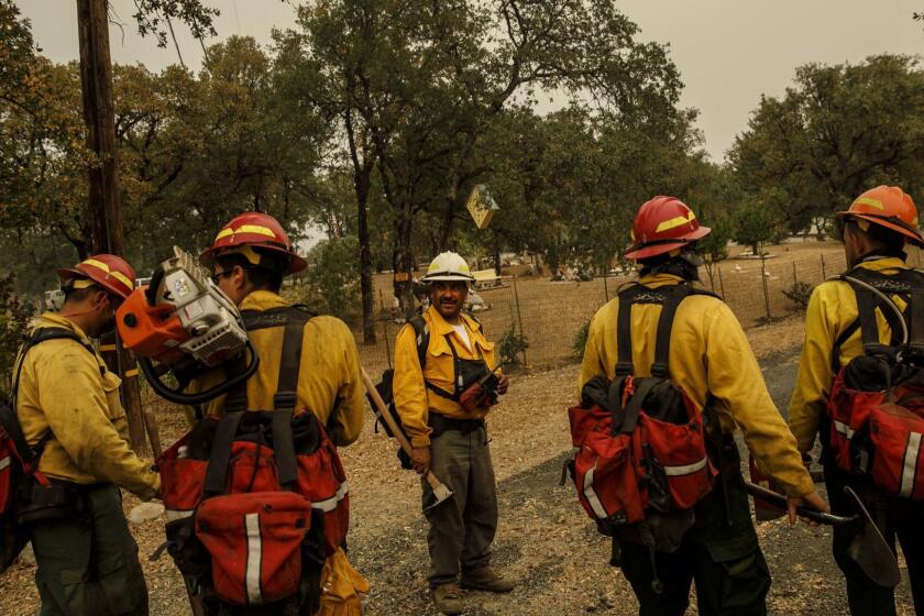 REDDING, CALIF. -- MONDAY, JULY 30, 2018: Frederico Rocha, center, leads his firefighters from S&R Contracting as they mop up heat spots near homes near Redding, Calif., on July 30, 2018. (Marcus Yam / Los Angeles Times)