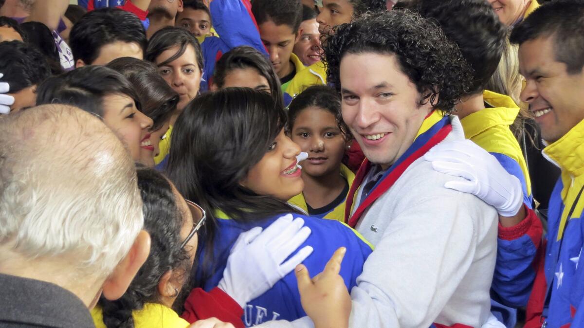 Gustavo Dudamel is greeted by music students in Venezuela in 2012.
