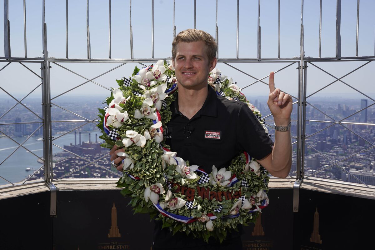 Marcus Ericsson, of Sweden, poses for pictures on the observation desk of the Empire State Building in New York, Tuesday, May 31, 2022. Ericsson won the 106th running of the Indianapolis 500 auto race on Sunday. (AP Photo/Seth Wenig)