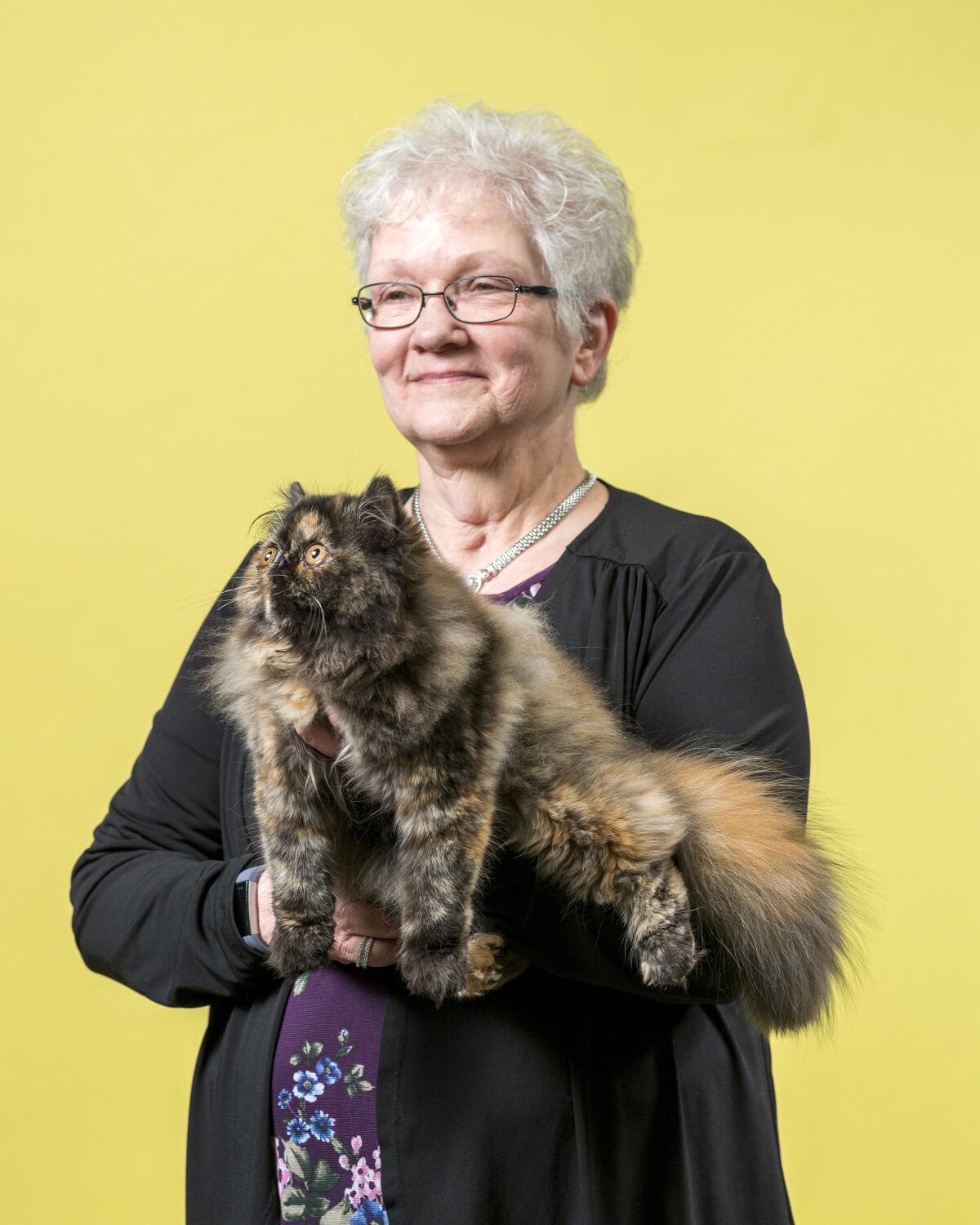 Bobbi Wilfon holds her Persian cat named Isabella.