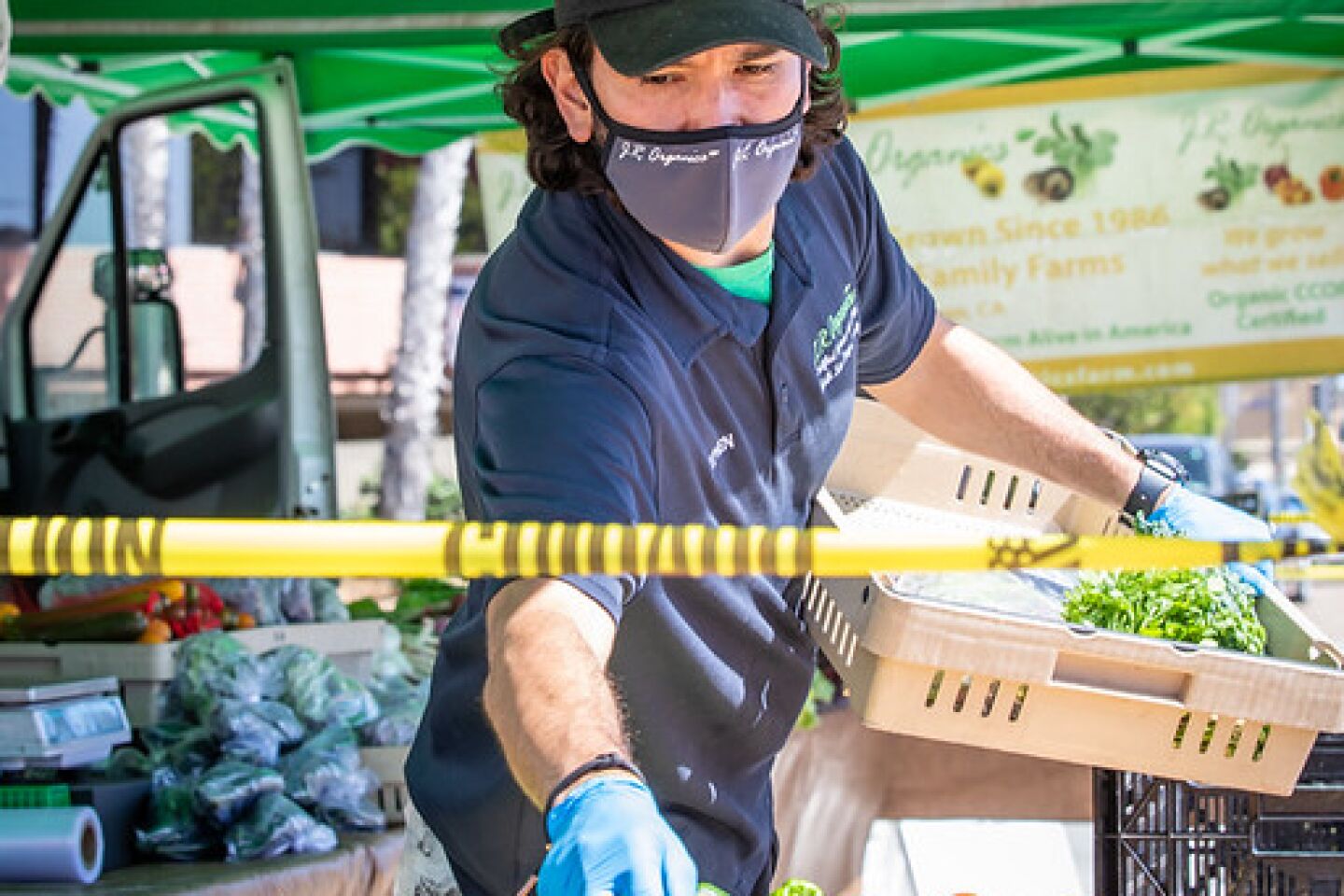 Stephen Clark works at the reopened Pacific Beach Tuesday Farmers’ Market on Bayard and Hornblend streets on May 19. The market is limited to farm and grocery products in accord with city of San Diego guidelines.