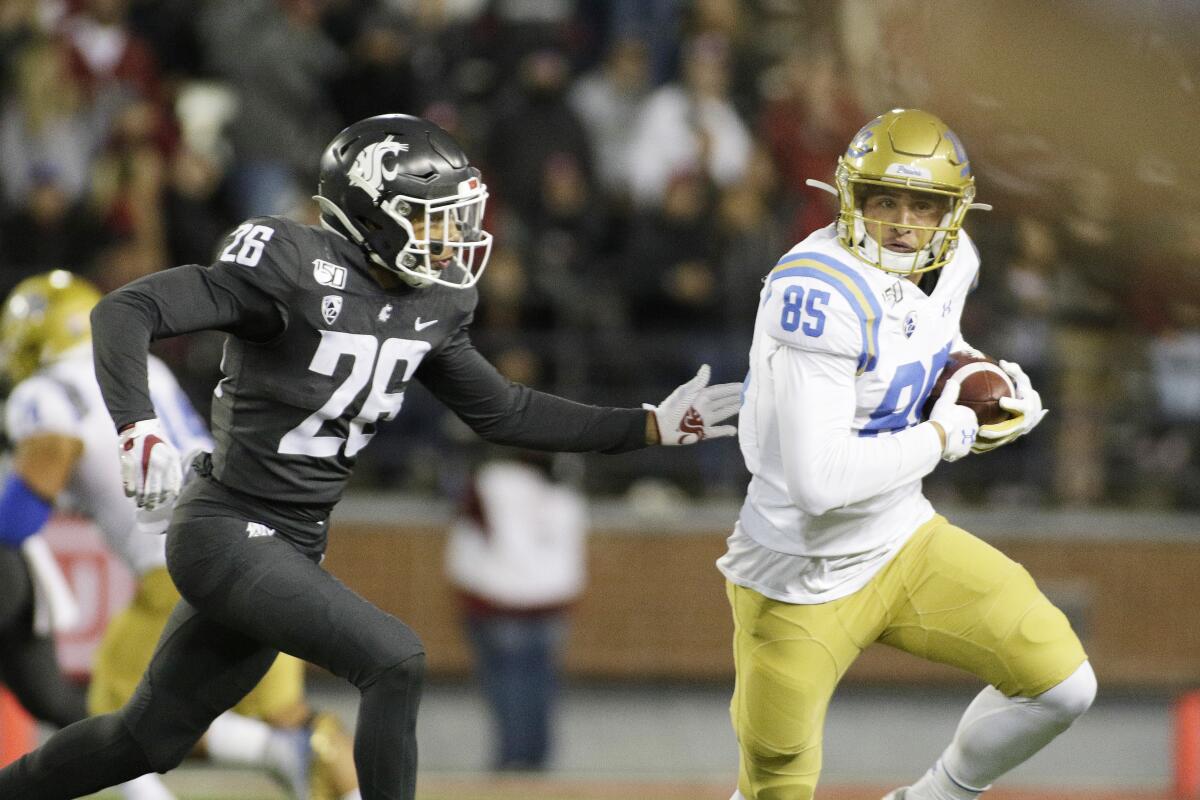 UCLA's Greg Dulcich runs with the ball while under pressure by Washington State safety Bryce Beekman in 2019.
