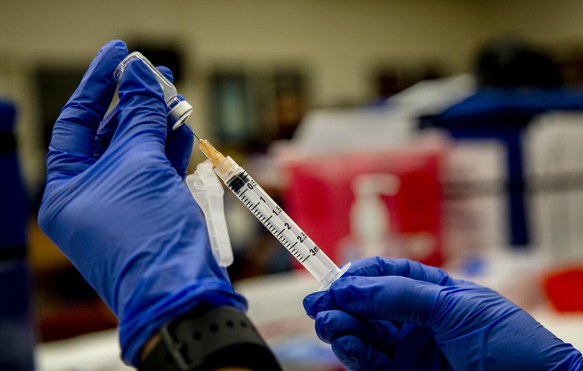 A nurse prepares a COVID-19 vaccine