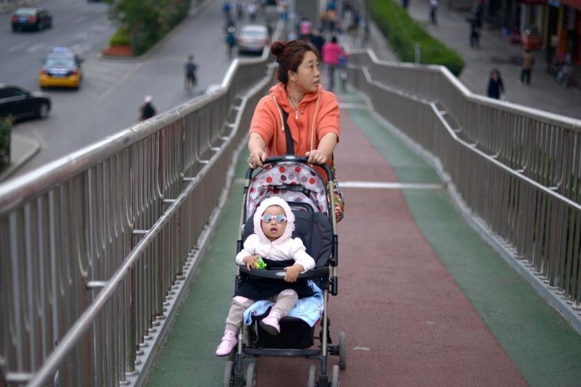 A woman pushes a baby carriage on an overpass in Beijing on May 8, 2014. China began to implement the loosening of its controversial one-child policy on January 17, when a province announced it has made it legal for couples to have two children if one parent is an only child. AFP PHOTO / WANG ZHAOWANG ZHAO/AFP/Getty Images ** OUTS - ELSENT and FPG - OUTS * NM, PH, VA if sourced by CT, LA or MoD ** ORG XMIT: CHI1405080558473426