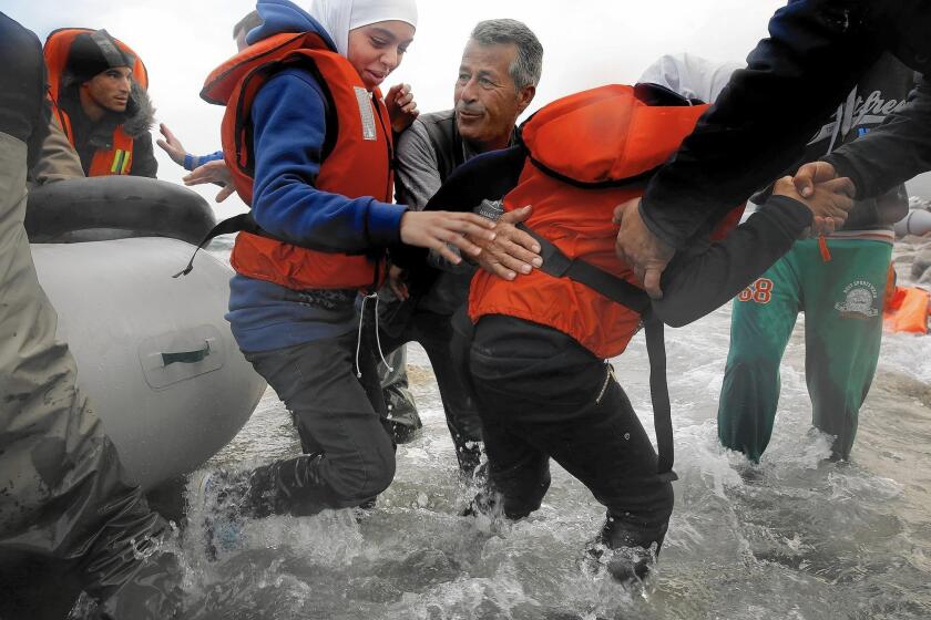 Two teen girls are helped off a dinghy after crossing from Turkey to Greece with their family. The overwhelming majority of refugees trying to reach Europe — more than 844,000, the U.N. says — do so by crossing the Aegean Sea.