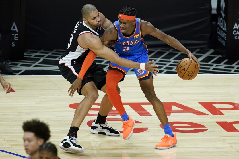 Clippers forward Nicolas Batum, left, defends against Oklahoma City Thunder guard Shai Gilgeous-Alexander.