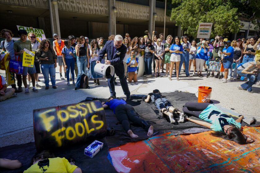 San Diego, - September 23: At Civic Center Plaza on Friday, Sept. 23, 2022 in San Diego, high school students staged a demonstration with pouring fake oil on themselves. Theo Martien, demanded, ”that Biden declares a climate emergency, that Gov Newsom ends oil drilling in California and that we swiftly and justly transition to renewable energy.” (Nelvin C. Cepeda / The San Diego Union-Tribune)