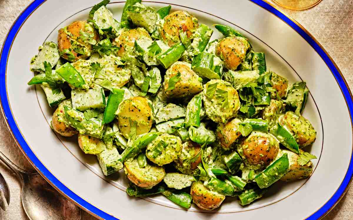 Green Potato Salad With Zhoug on a blue-rimmed white oval platter.