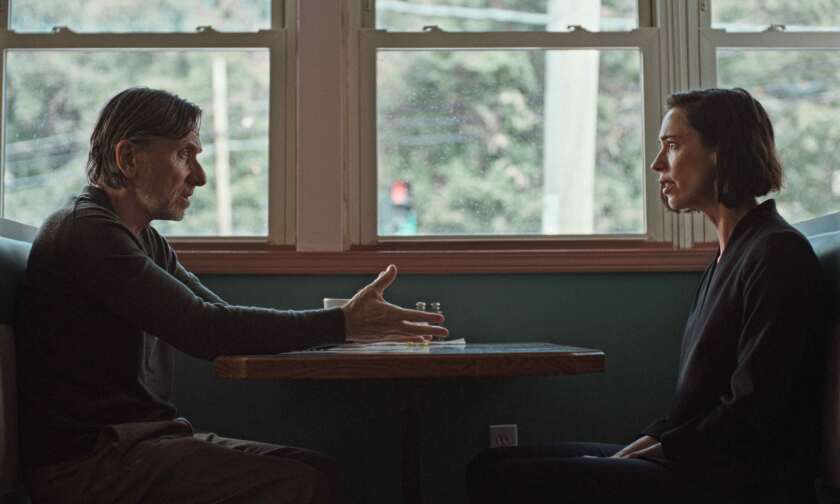 A man and a woman sit across from each other at a restaurant.