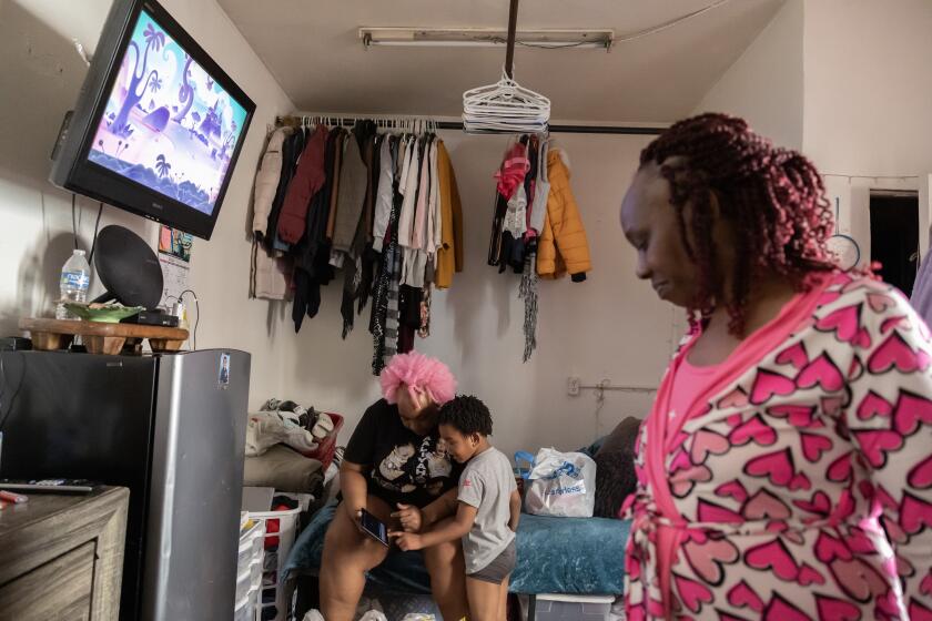 LOS ANGELES, CA - JULY 05: Tarhjia (cq) Easterly, 54, right, lives with her daughter Jasmine Phillips, 36 and grandson, King-AskariX Afraka (cq), 4, in their one room apartment. Tenants at 5700 S. Hoover Street are living in squalid and dangerous apartments. They don't have hot water, there is mold, rats and trash problems. They haven't heard anything from city officials following their visit months ago. Photographed on Friday, July 5, 2024 at 5700 S. Hoover Street in Los Angeles, CA. (Myung J. Chun / Los Angeles Times)