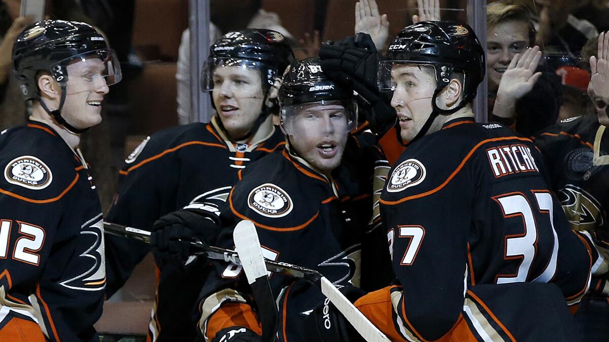 Ducks left wing Nick Ritchie (37) is congratulated by teammates, from left, Josh Manson, Hampus Lindholm and Ondrej Kase after scoring against the Senators on Dec. 11 at Honda Center.