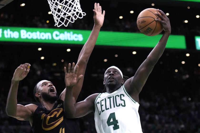 Boston Celtics guard Jrue Holiday, right, drives to the basket against Cleveland Cavaliers forward Evan Mobley during the second half of Game 1 of an NBA basketball second-round playoff series Tuesday, May 7, 2024, in Boston. (AP Photo/Charles Krupa)