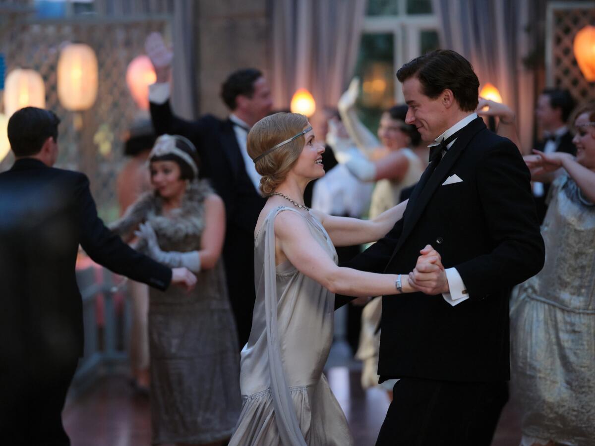 Woman in a dress and a man in a tux dance 