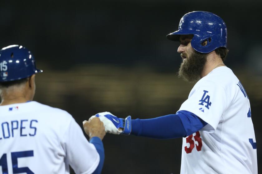 Dodgers outfielder Scott Van Slyke is congratulated by first base coach Davey Lopes after delivering a run-scoring single against the Colorado Rockies last season.