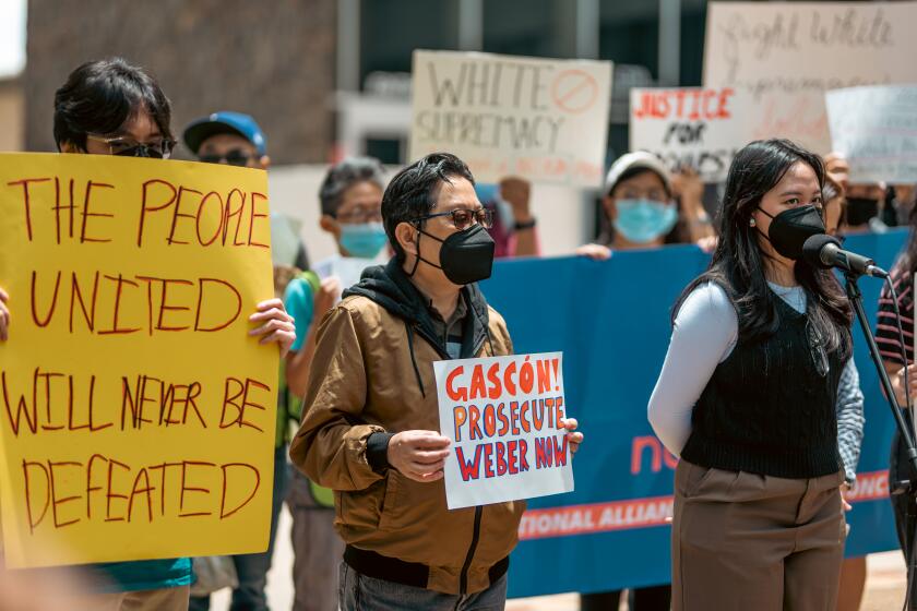 Patricia Roque (right) and her father Gabriel (center) attended a rally outside of the Los Angeles County district attorney's office Van Nuys branch on Friday.
