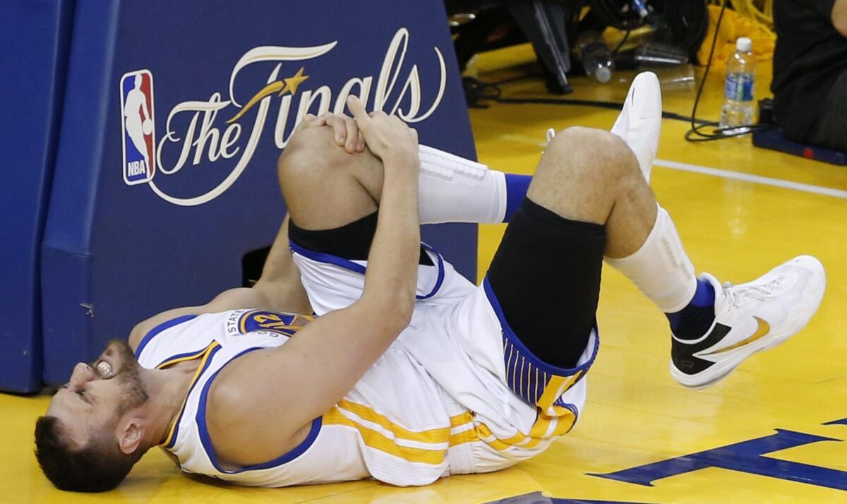 Golden State center Andrew Bogut holds his knee in pain during Game 5 against Cleveland.