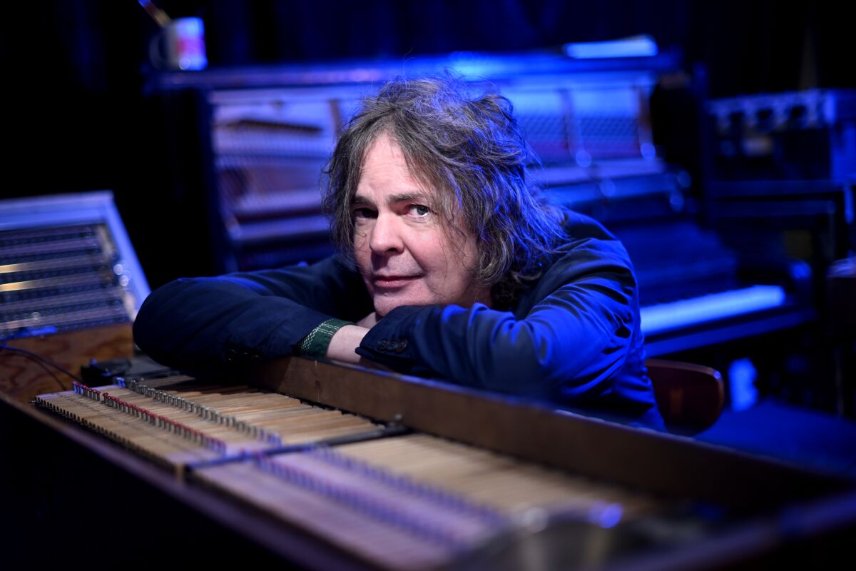 A man leans on machinery at a recording studio.