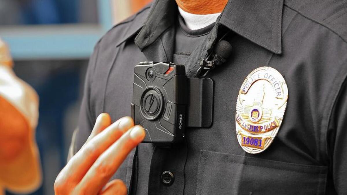 LAPD Officer Jim Stover demonstrates how an officer turns on the new Taser body camera at a news conference in 2015.
