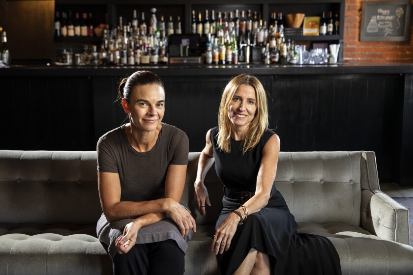 Restaurateurs Suzanne Goin and Caroline Styne sit on a couch.