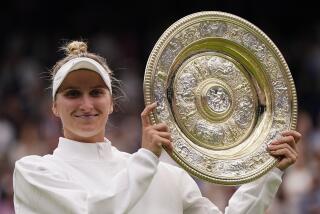 The Czech Republic's Marketa Vondrousova holds up the Wimbledon trophy and smiles 