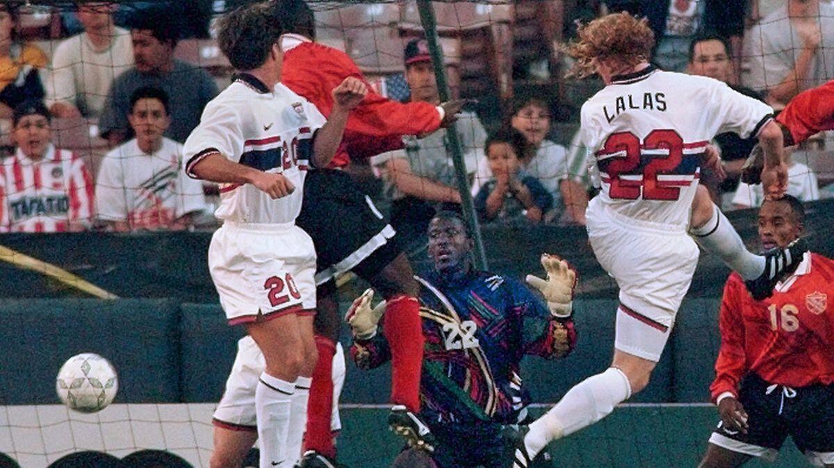 Trinadad & Tobago goalie Ross Russell (22) watches the ball go into the net on an assist by USA's Alexi Lalas (22) in the first half of their CONCACAF Gold Cup game in Anaheim on Jan 13, 1996. Also pictured are USA's Paul Caliguri (20).