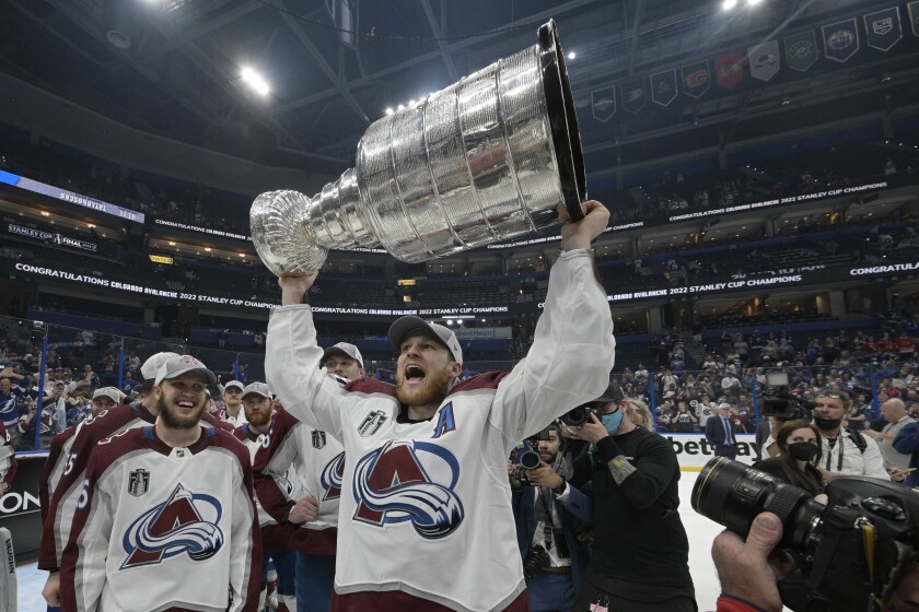 Colorado Avalanche center Nathan MacKinnon lifts the Stanley Cup after the team defeated the Tampa Bay Lightning in Game 6 of the NHL hockey Stanley Cup Finals on Sunday, June 26, 2022, in Tampa, Fla. (AP Photo/Phelan Ebenhack)