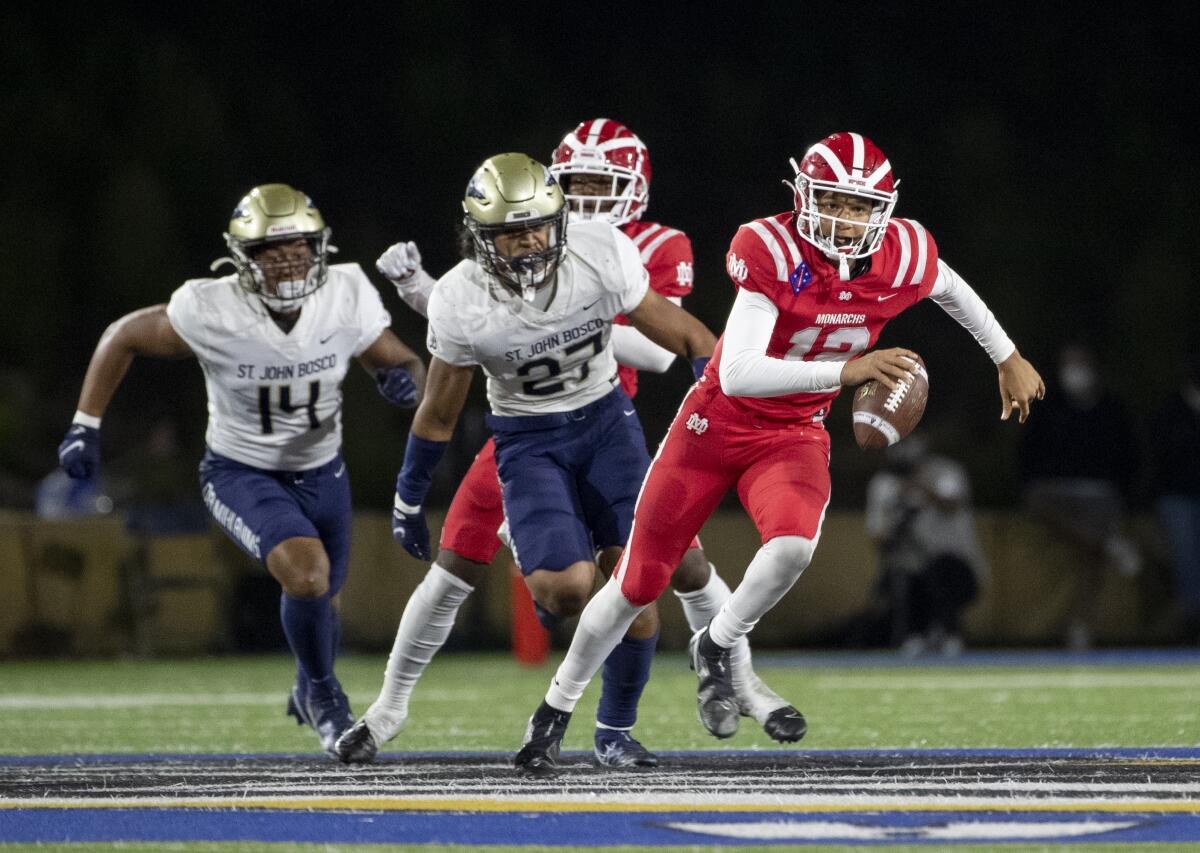 Mater Dei quarterback Elijah Brown scampers for extra yardage while St. John Bosco defenders give chase.
