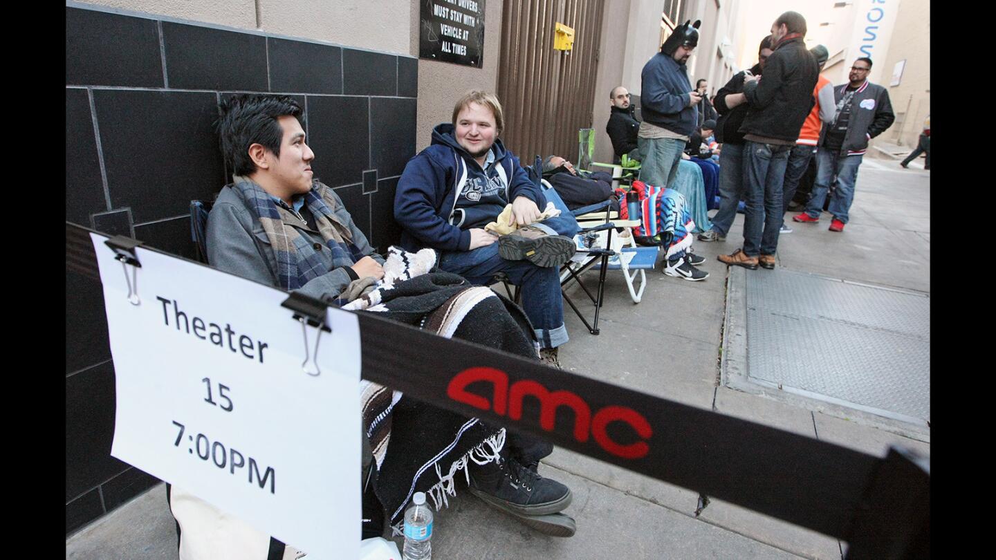 Burbank residents Daniel Cruz and Miles Bonner are first in line for the 7PM showing of "Star Wars the Force Awakens" at the Burbank AMC along with Cruz's father, Ruben, sleeping in the background, on Thursday, December 17, 2015. They got in line at 6:30 AM.
