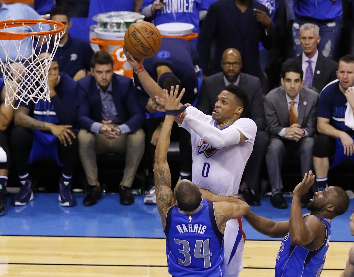 Thunder guard Russell Westbrook (0) goes up for a basket over Mavericks guards Devin Harris (34) and Raymond Felton (2) during the second half of Game 5.