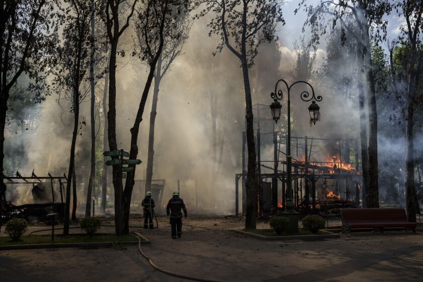 Firefighters extinguish a fire following a Russian bombardment at a park in Kharkiv, Ukraine, Tuesday, May 3, 2022. (AP Photo/Felipe Dana)