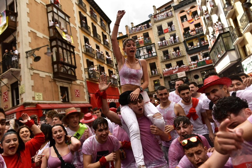 Revelers celebrate while waiting for the launch of the 'Chupinazo' rocket, to mark the official opening of the 2022 San Fermin fiestas in Pamplona, Spain, Wednesday, July 6, 2022. The blast of a traditional firework opens Wednesday nine days of uninterrupted partying in Pamplona's famed running-of-the-bulls festival which was suspended for the past two years because of the coronavirus pandemic. (AP Photo/Alvaro Barrientos)