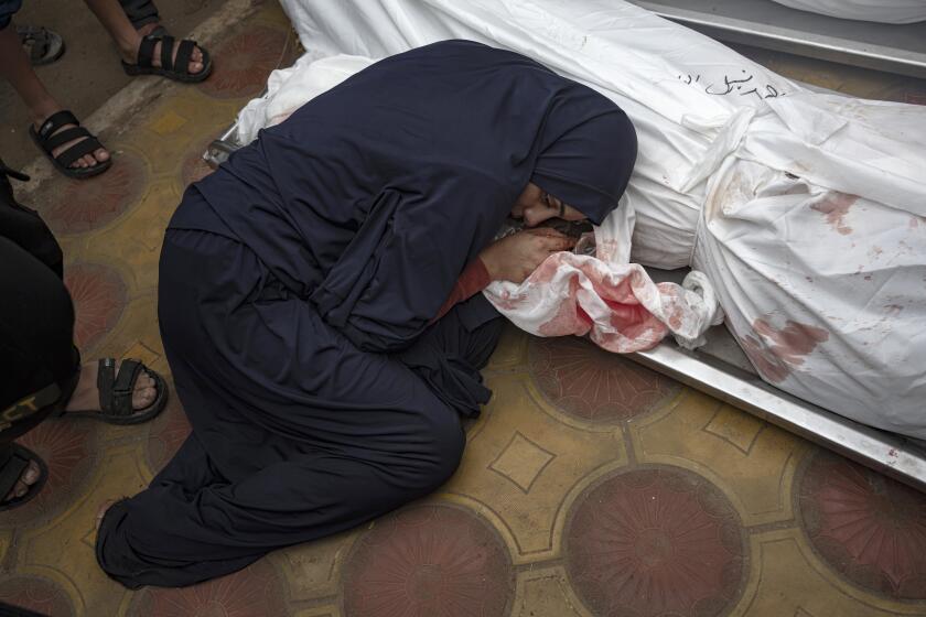 Una mujer llora a su esposo e hijo muertos en un bombardeo del ejército israelí en la Franja de Gaza, en el hospital de Jan Yunis, el 5 de diciembre de 2023. (AP Foto/Fatima Shbair)