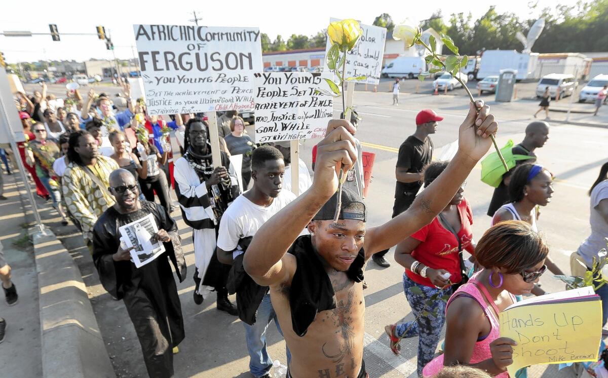 Protesters march in Ferguson, Mo., over the police slaying of Michael Brown. Officials pleaded with people to stay home Tuesday night, to no avail.