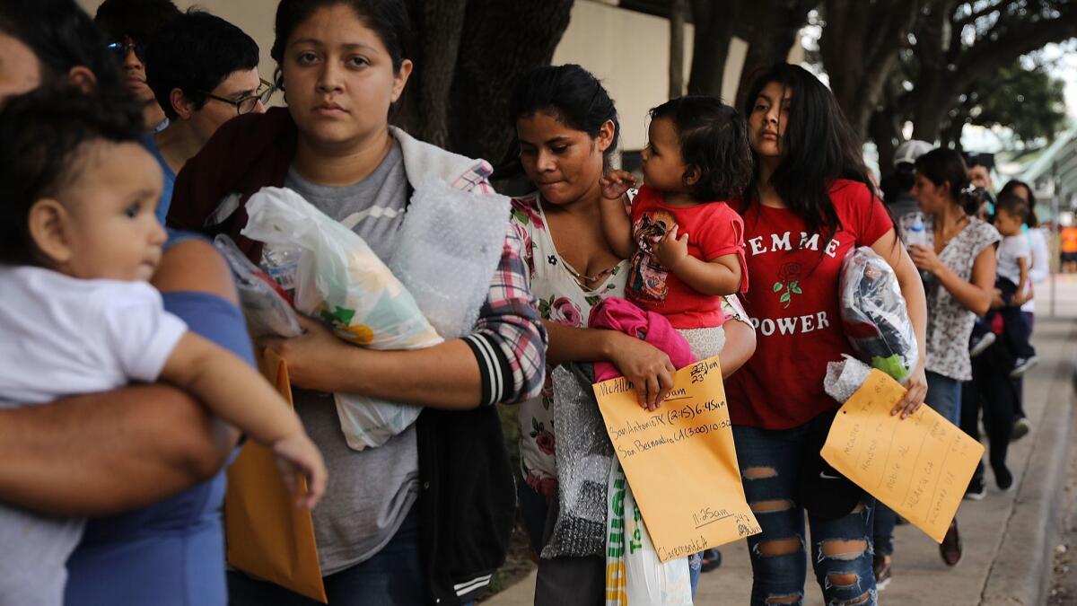 Volunteers walk dozens of women and their children, many fleeing poverty and violence in Honduras, Guatamala and El Salvador, to a relief center following their release from Customs and Border Protection on June 22 in McAllen, Texas.