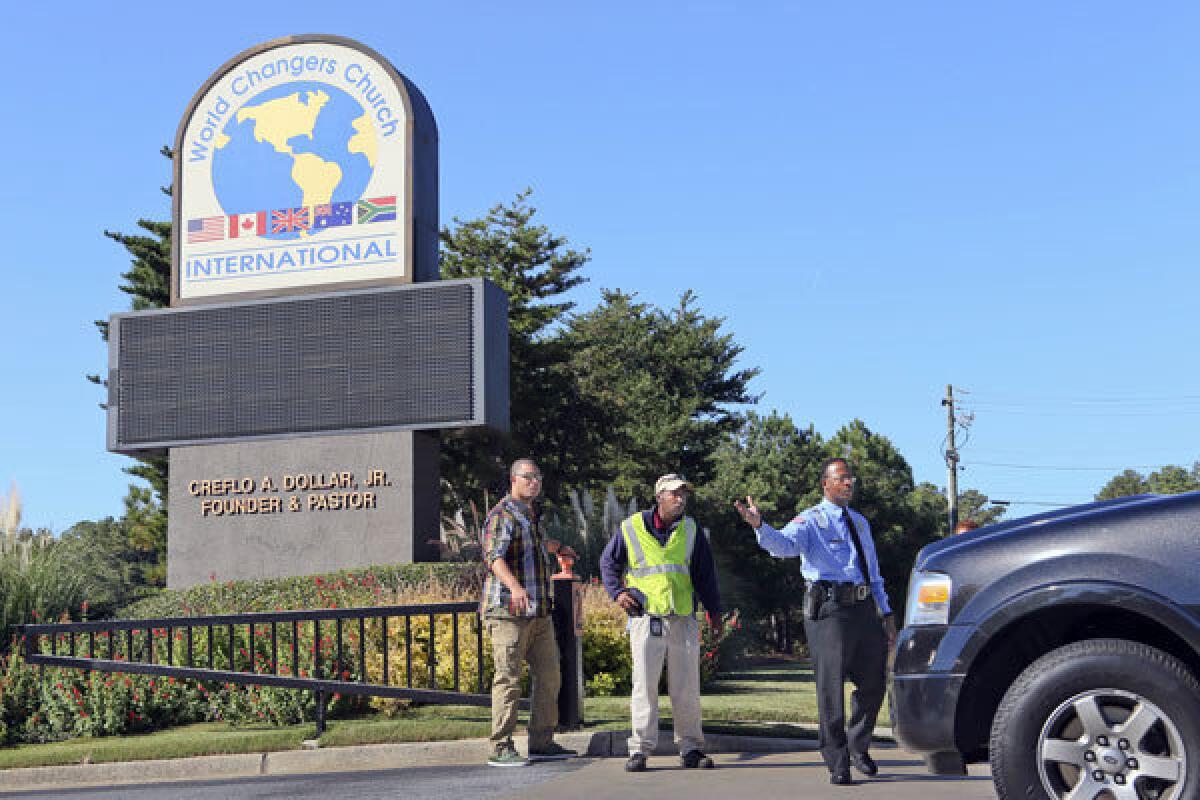Security personnel stop cars coming onto the campus of World Changers Church International in College Park, Ga.