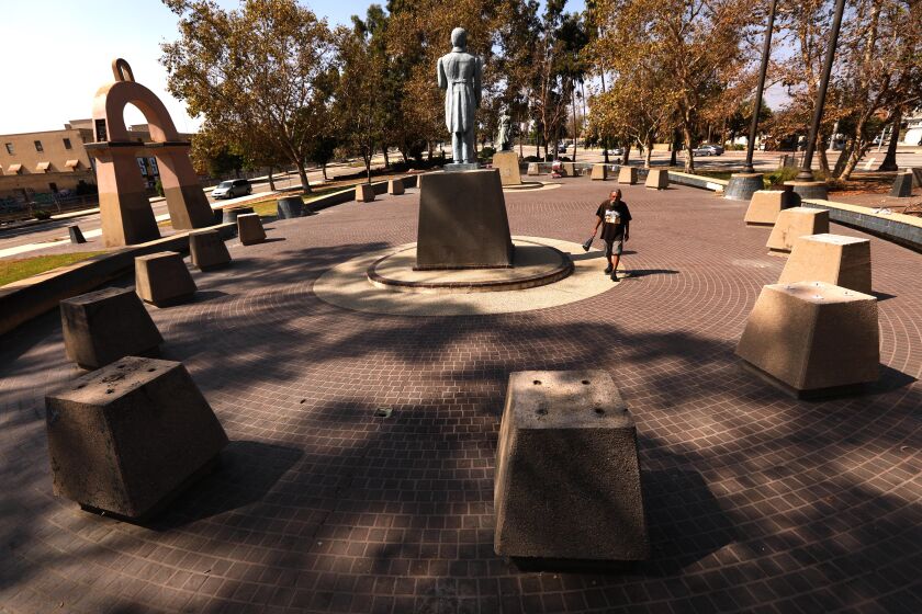 LOS ANGELES, CA - SEPTEMBER 30, 2022 - - Paul Carrera, 65, walks through El Parque de Mexico in Lincoln Park in Lincoln Heights on September 30, 2022. Empty pedestals are all that is left where copper busts of Mexican heroes once rested before being stolen by thieves over the years. The only two statues remaining at the site are of Efren de los Rios, center, and Benito Juarez, background. (Genaro Molina / Los Angeles Times)