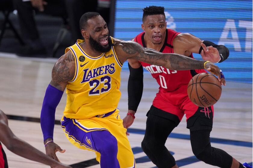 Los Angeles Lakers' LeBron James (23) reaches for the ball as Houston Rockets' Russell Westbrook defends.