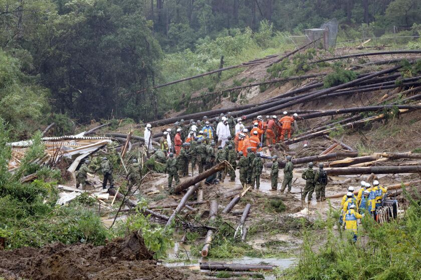 Rescuers conduct a search operation at the site of a landslide in Mimata, Miyazaki Prefecture, southern Japan, Monday Sept. 19, 2022. Powerful Typhoon Nanmadol slammed ashore in southern Japan on Sunday as it pounded the region with strong winds and heavy rain, causing blackouts, paralyzing ground and air transportation and prompting the evacuation of thousands of people. (Kyodo News via AP)
