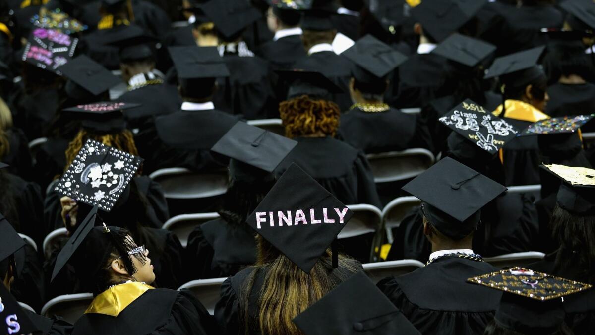 University graduates put messages on their mortarboard hats on the campus of the University of Maryland on May 17, 2013.