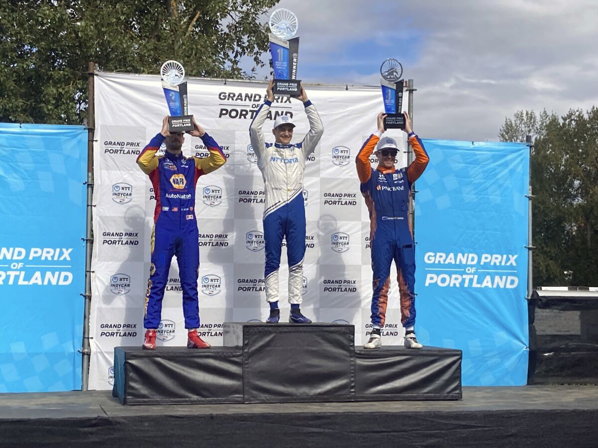 Alex Palou, center, celebrates his third IndyCar win of the season on Sunday, Sept. 12, 2021 at Portland International Raceway in Portland, Ore. Palou’s win moved him back atop the IndyCar championship standings with two races remaining. Alexander Rossi finished second and Scott Dixon, teammates with Palou at Chip Ganassi Racing, finished third. (AP Photo/Jenna Fryer)