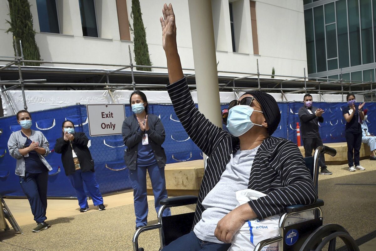 FILE - In this May 19, 2020, file photo, Karen Parker-Bryant, 64, raises a hand skyward after she was released from Clovis Community Hospital after a battle with COVID-19, in Fresno, Calif. Hospitals in the heart of California’s Central Valley are running out of beds in their intensive care units because of an influx of coronavirus patients, prompting officials on Friday, Sept. 3, 2021, to declare an official “surge." (John Walker/The Fresno Bee via AP, File)