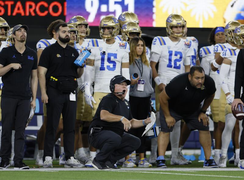 UCLA coach Chip Kelly crouches on the sideline reacts to a play during the LA Bowl against Boise State
