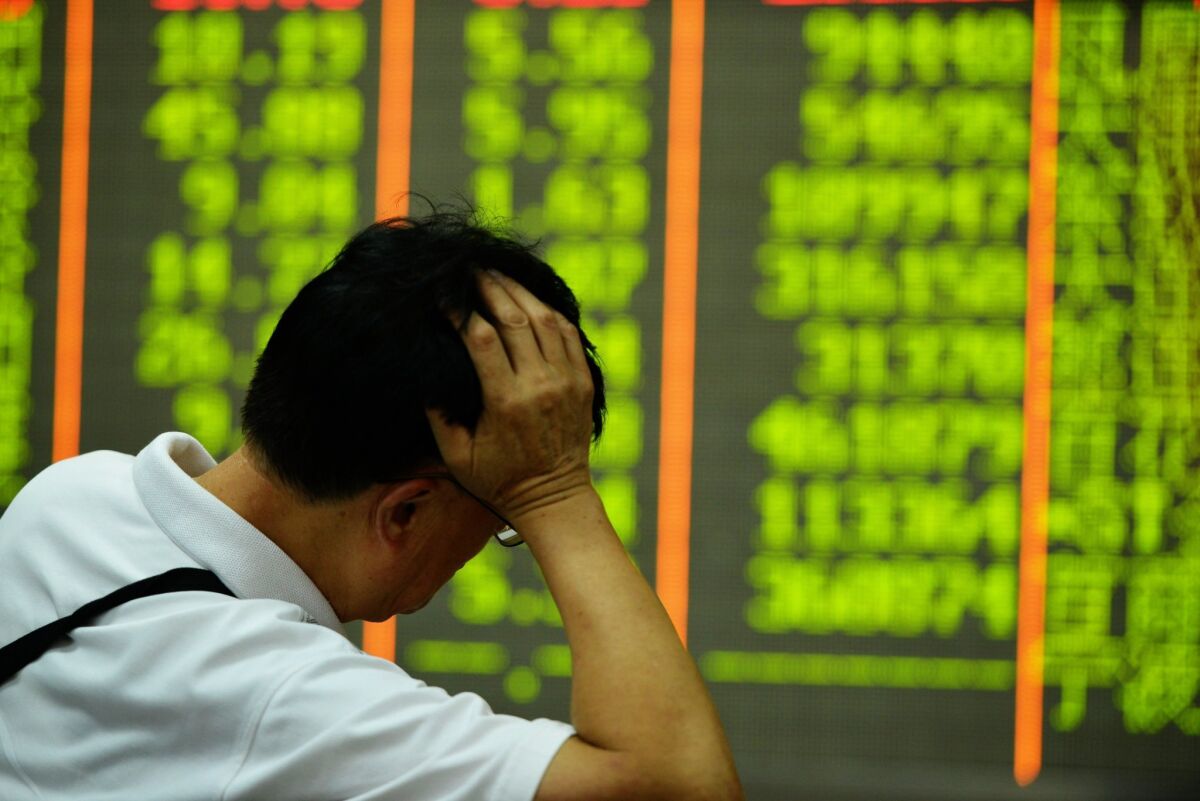 An man in a securities firm in Hangzhou, China, watches a screen that shows share prices on July 27.
