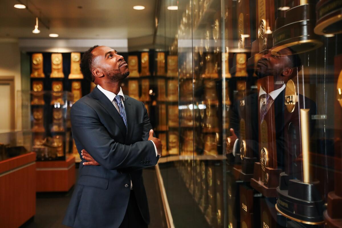 A portrait of Martin Jarmond looking at a UCLA trophy case.
