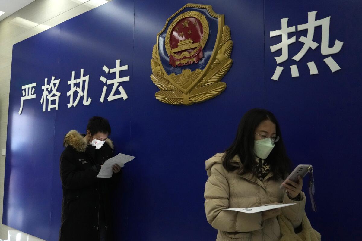 Residentes se forman en una estación de policía para presentar sus solicitudes de pasaporte en Beijing