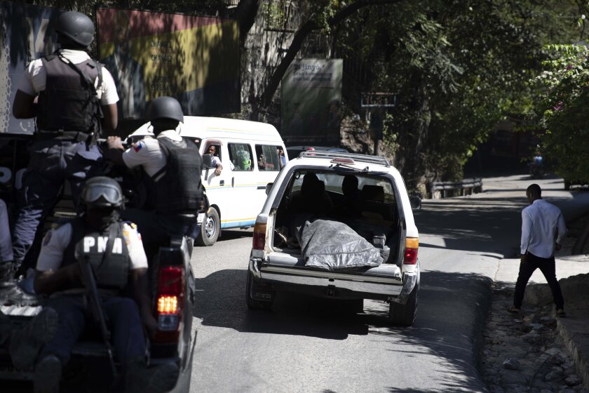 Police carry away the bodies of slain journalists in Port-au-Prince, Haiti, Friday, Jan. 7, 2022. At least two journalists were killed by gangs on Jan. 6, according to Godson Lebrun, President of AHML, the Haitian Online Media Association. (AP Photo/Odelyn Joseph)